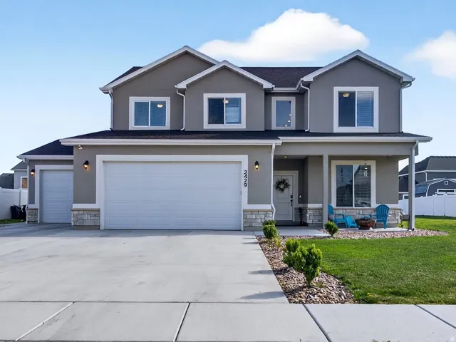 Traditional-style home with a porch, large concrete driveway, an attached garage, rv parking
