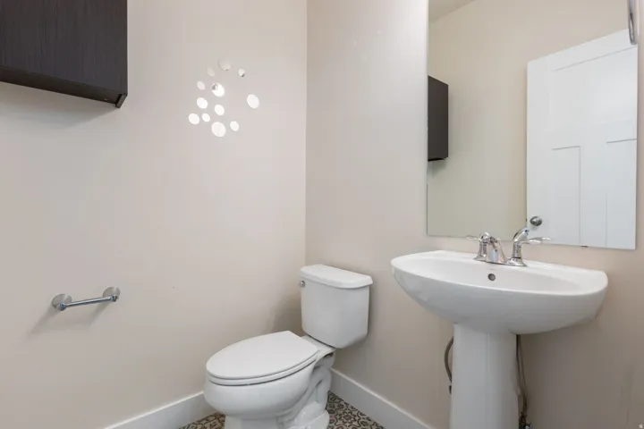 Half bathroom with baseboards and toilet