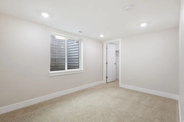 Unfurnished room featuring light colored carpet, recessed lighting, and a smoke detector