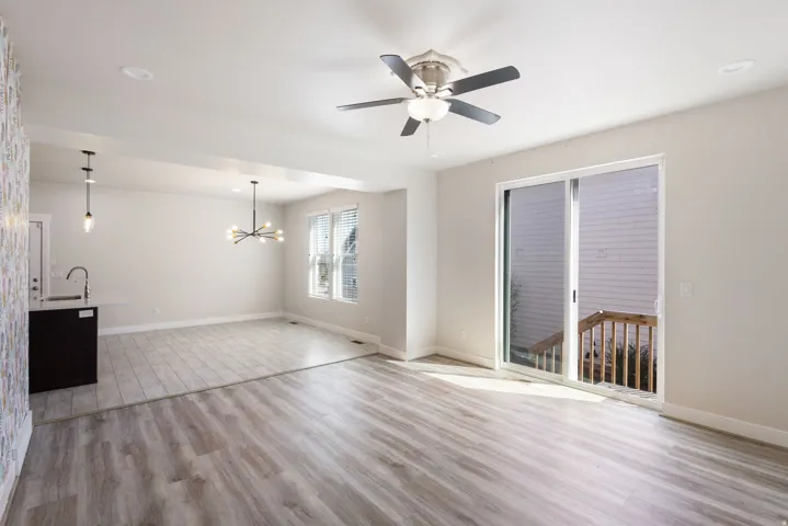 Unfurnished living room with light wood-style flooring, ceiling fan, and hanging lights