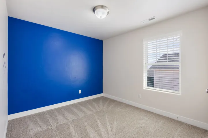 Empty room featuring baseboards and light colored carpet