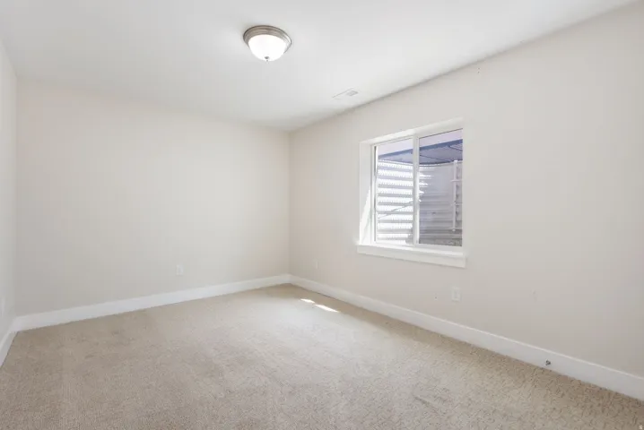 Empty room featuring light colored carpet and baseboards