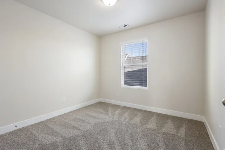Spare room featuring light colored carpet and baseboards