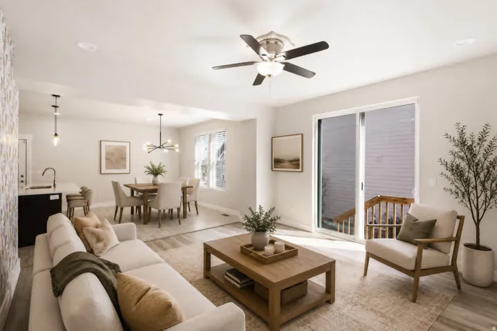 Open-concept living space featuring wood-finish flooring, a contemporary ceiling fan, and a sliding glass door to exterior
