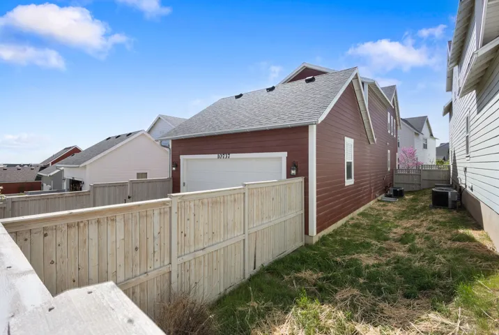 View of home's exterior with roof with shingles, a residential view, and a garage