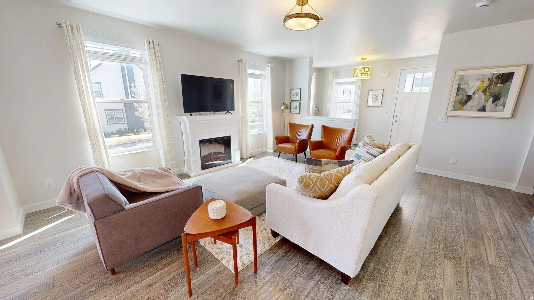 Living room featuring light wood-style flooring and a glass covered fireplace