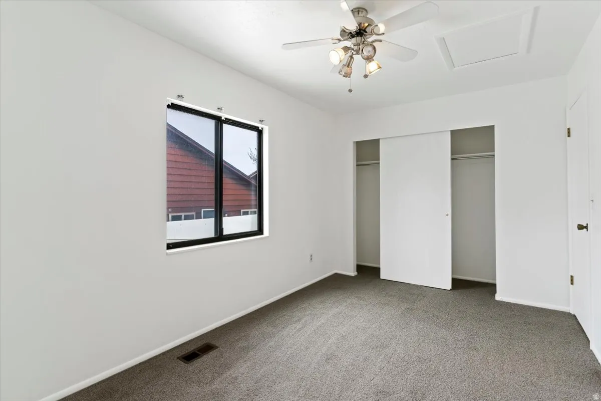 Unfurnished bedroom featuring carpet floors, a closet, and a ceiling fan