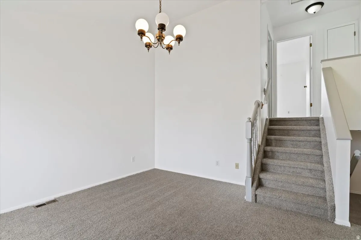 Stairway featuring carpet and hanging lights