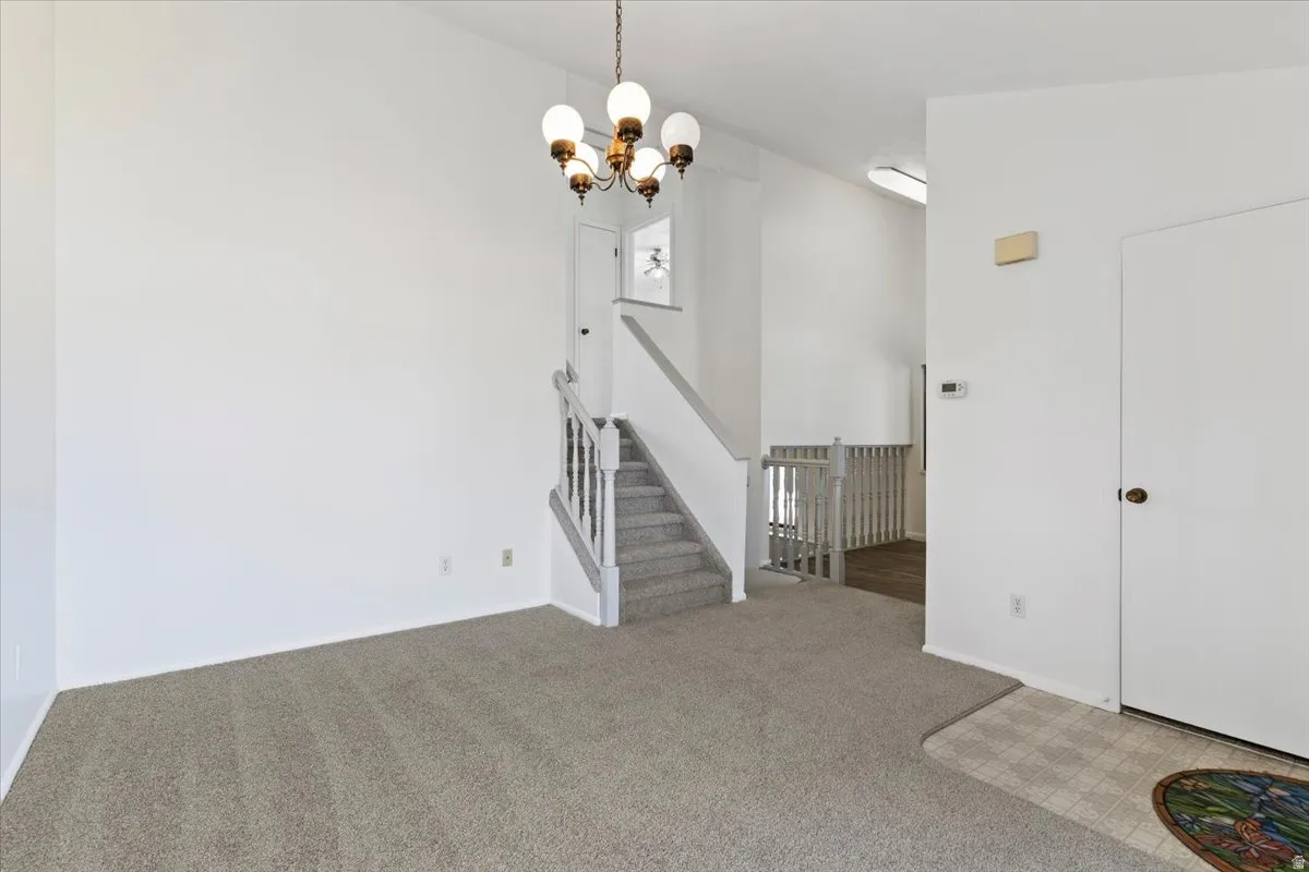Unfurnished dining area with carpet flooring and suspended lighting