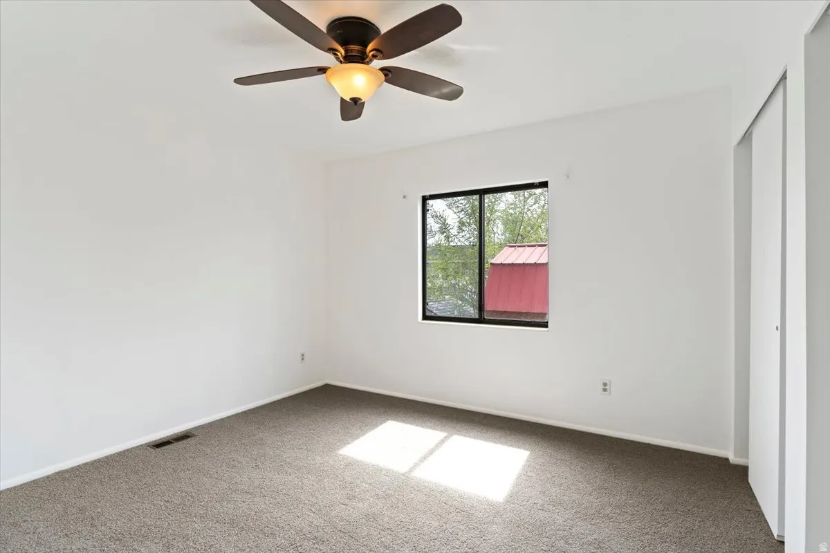 Unfurnished bedroom with a ceiling fan, carpet flooring, and a closet