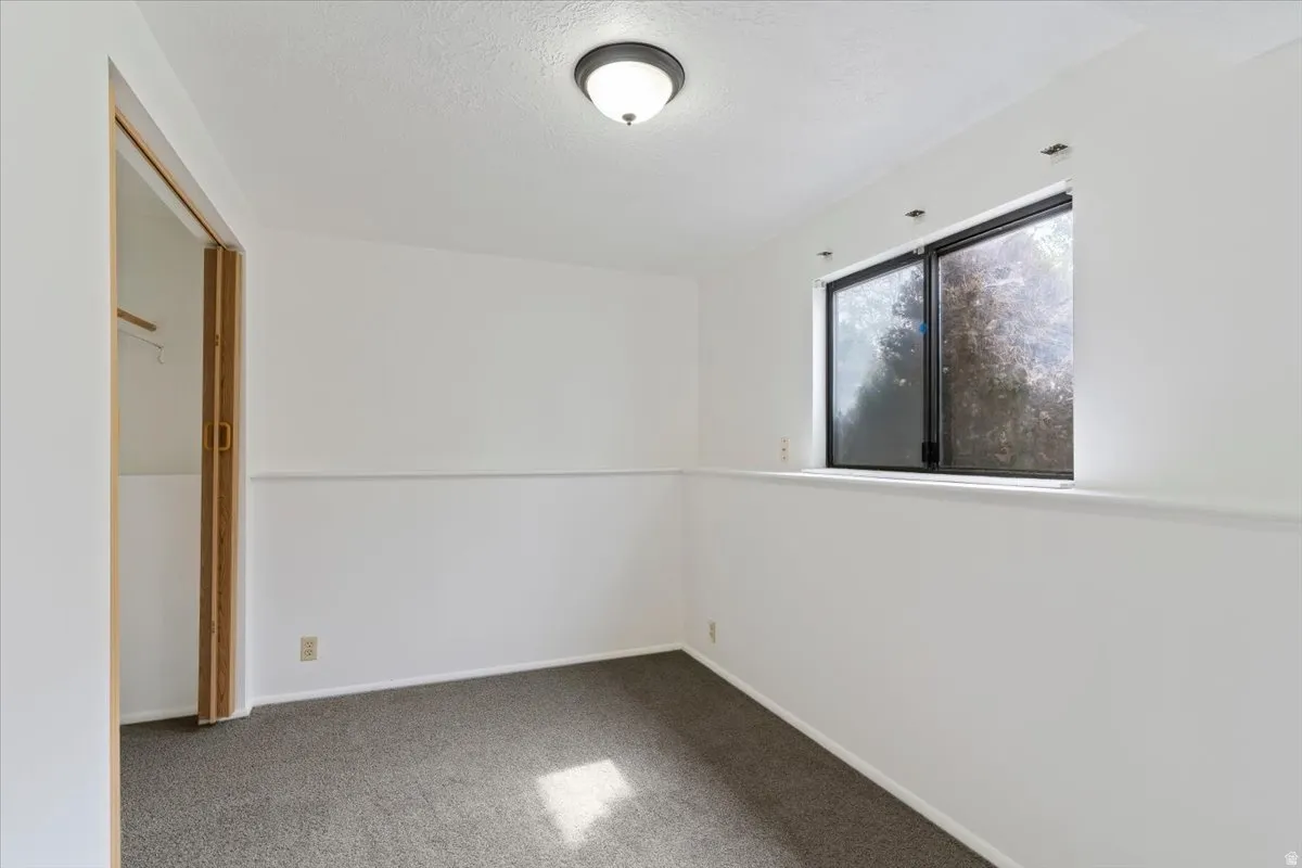 Unfurnished bedroom with carpet floors and a textured ceiling