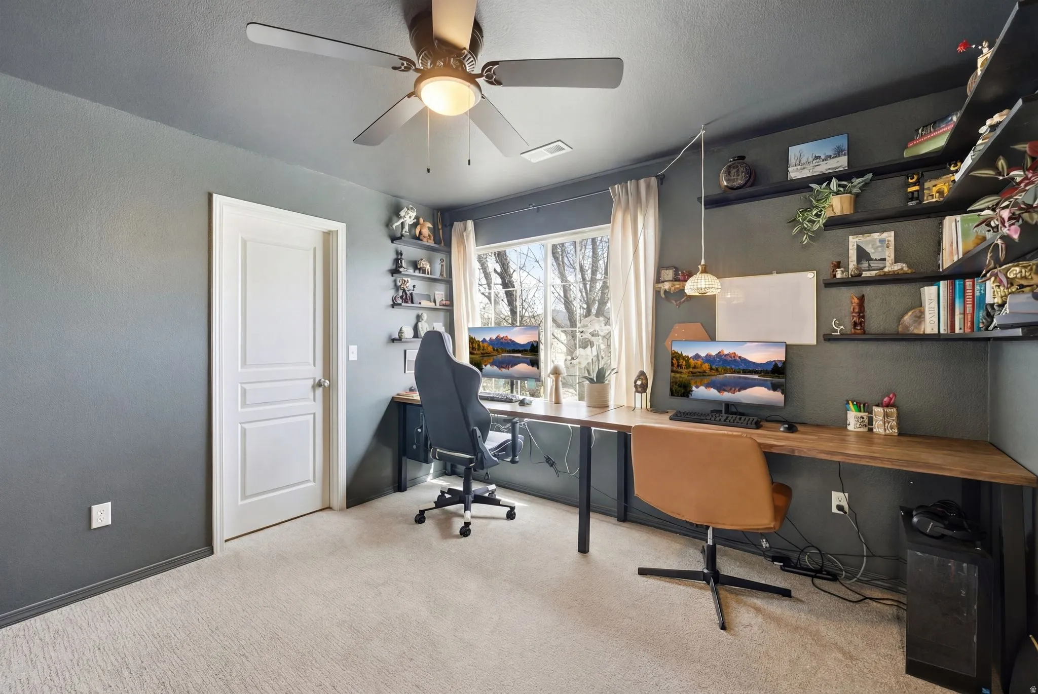 Office with a ceiling fan, light carpet, and built in desk