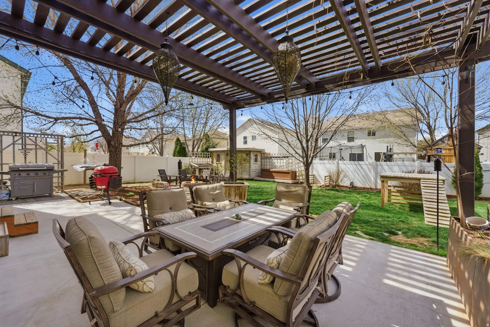 Fenced backyard with outdoor dining space, a patio, a residential view, and a grill