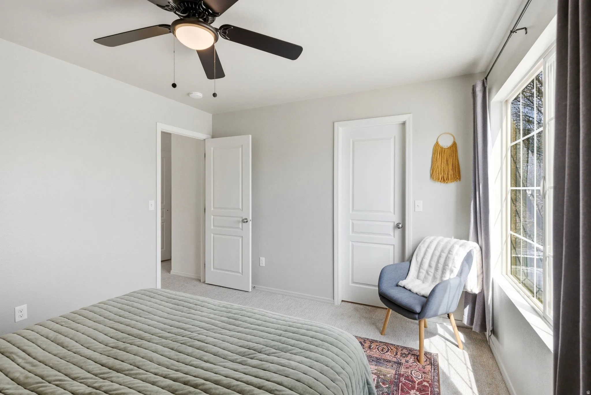 Bedroom featuring light carpet and a ceiling fan