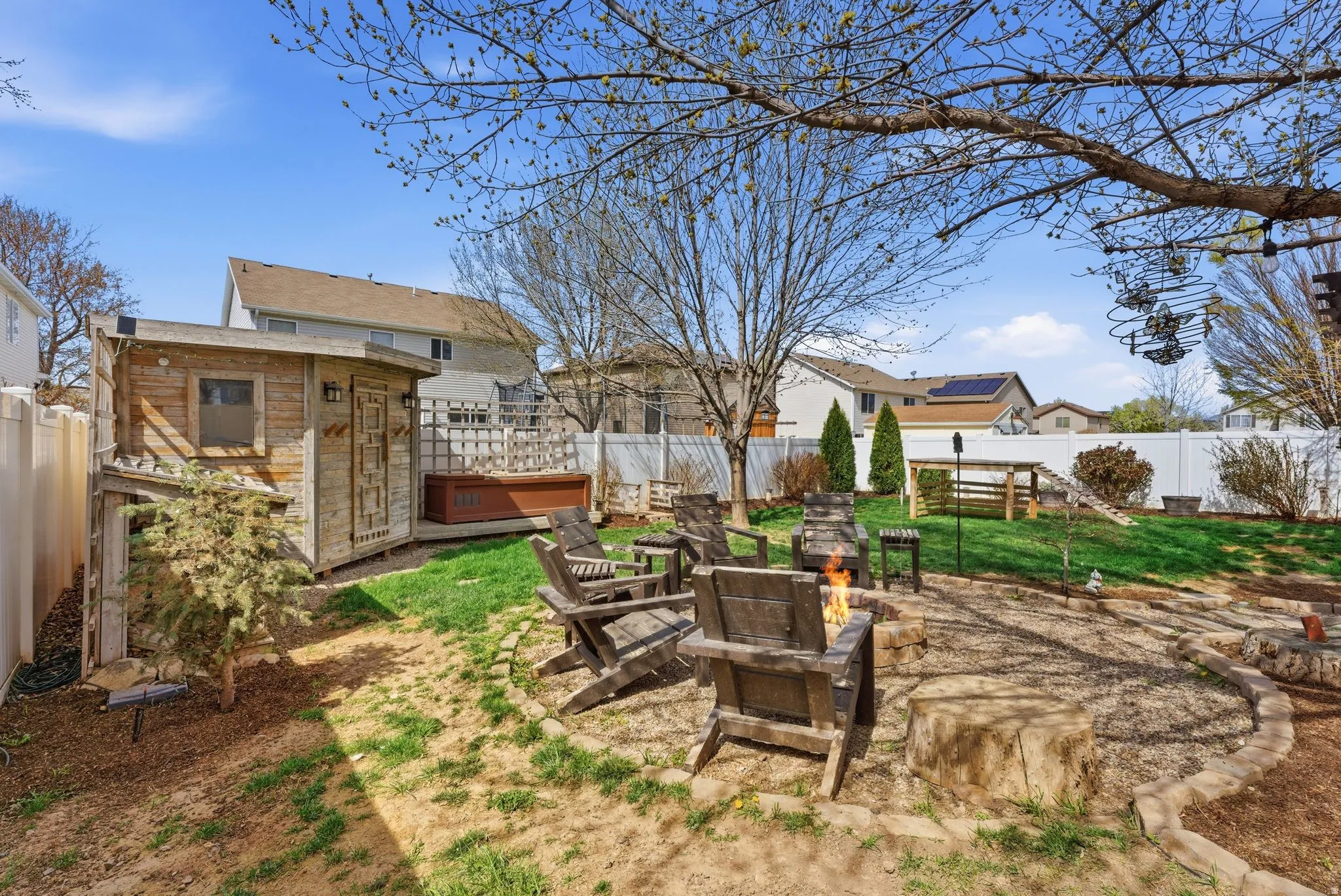 Fenced backyard featuring an outdoor fire pit, a patio, and a storage shed