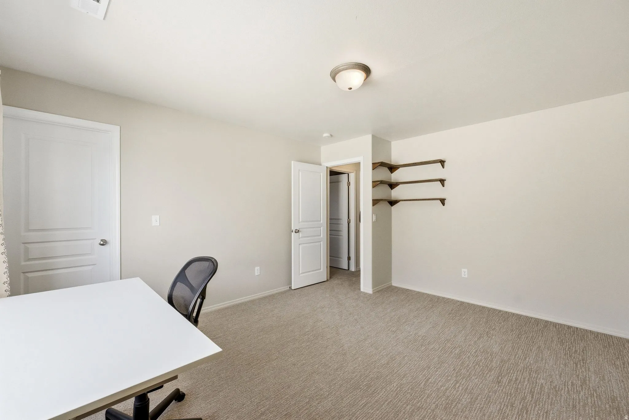 Home office featuring light colored carpet and baseboards