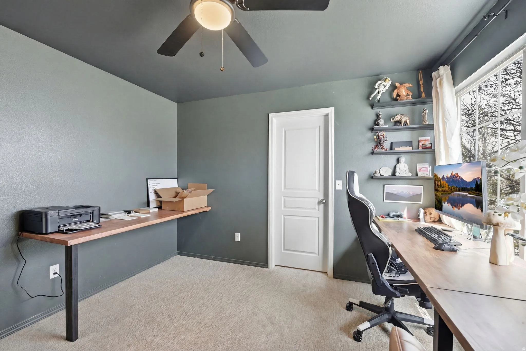 Office space featuring light carpet and a ceiling fan