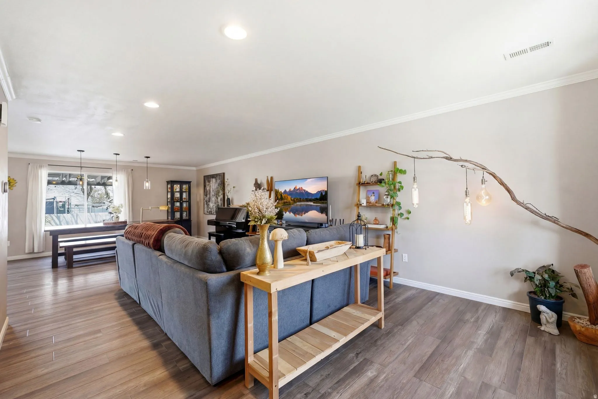 Living area with wood finished floors, recessed lighting, and crown molding