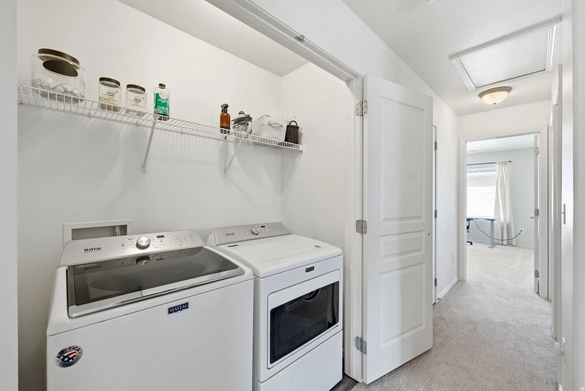 Laundry area with washing machine and dryer and light colored carpet