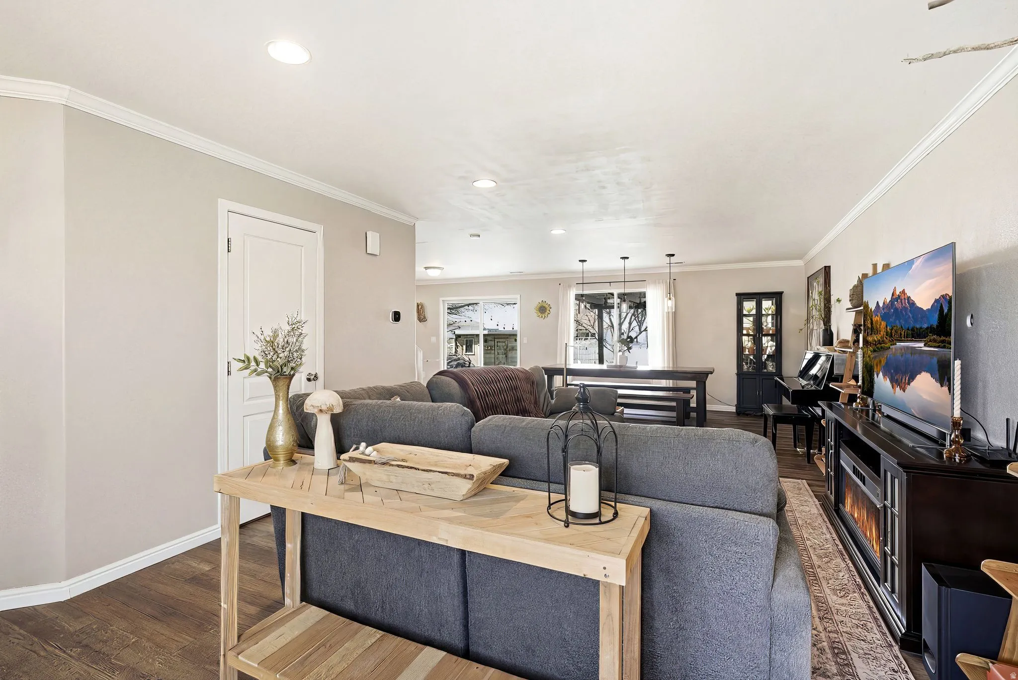 Living room featuring wood finished floors, ornamental molding, and recessed lighting