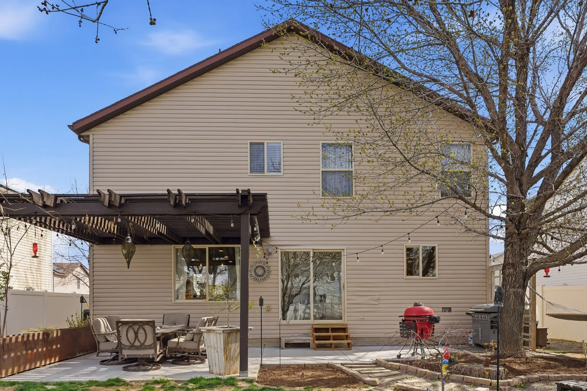 Rear view of house featuring a patio, entry steps, and a pergola