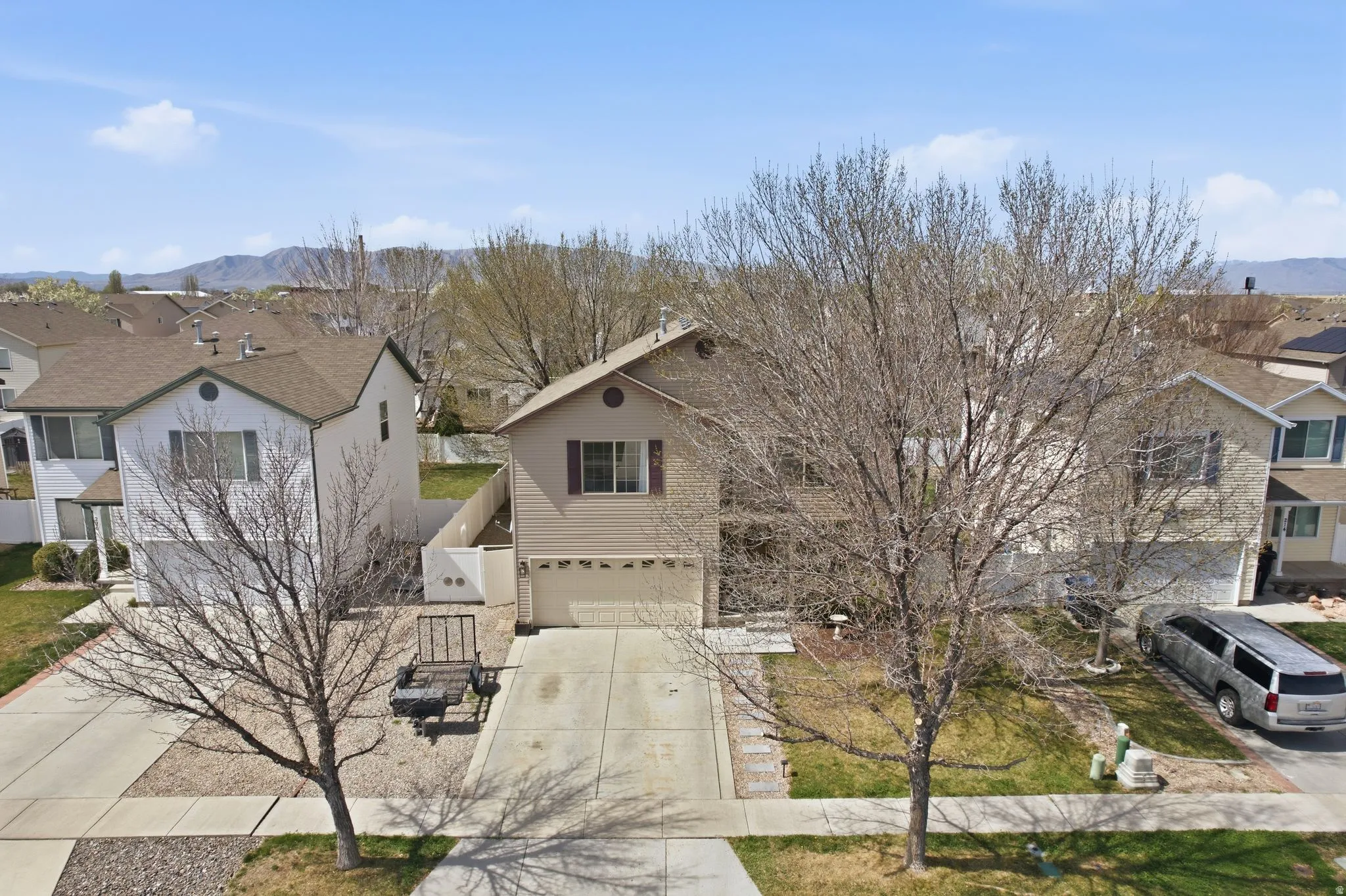 Traditional-style house featuring a residential view, concrete driveway, a garage, and a mountain view