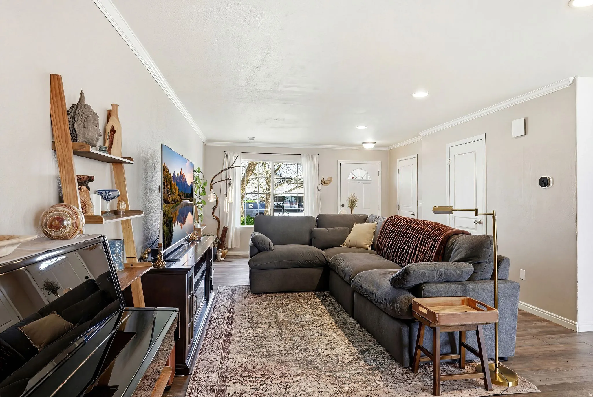 Living area with ornamental molding, wood finished floors, and recessed lighting