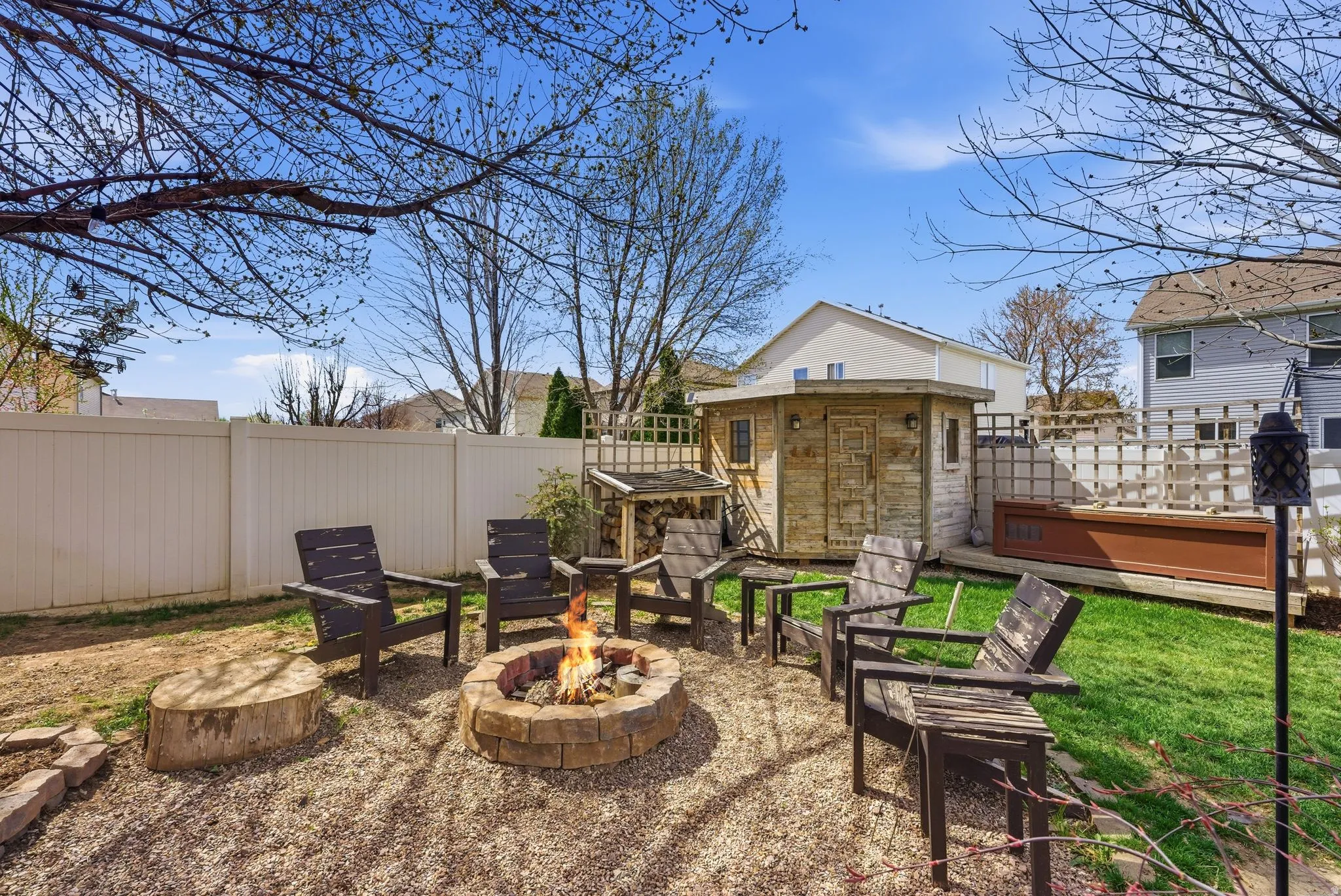 Fenced backyard featuring a patio, an outdoor fire pit, and a shed