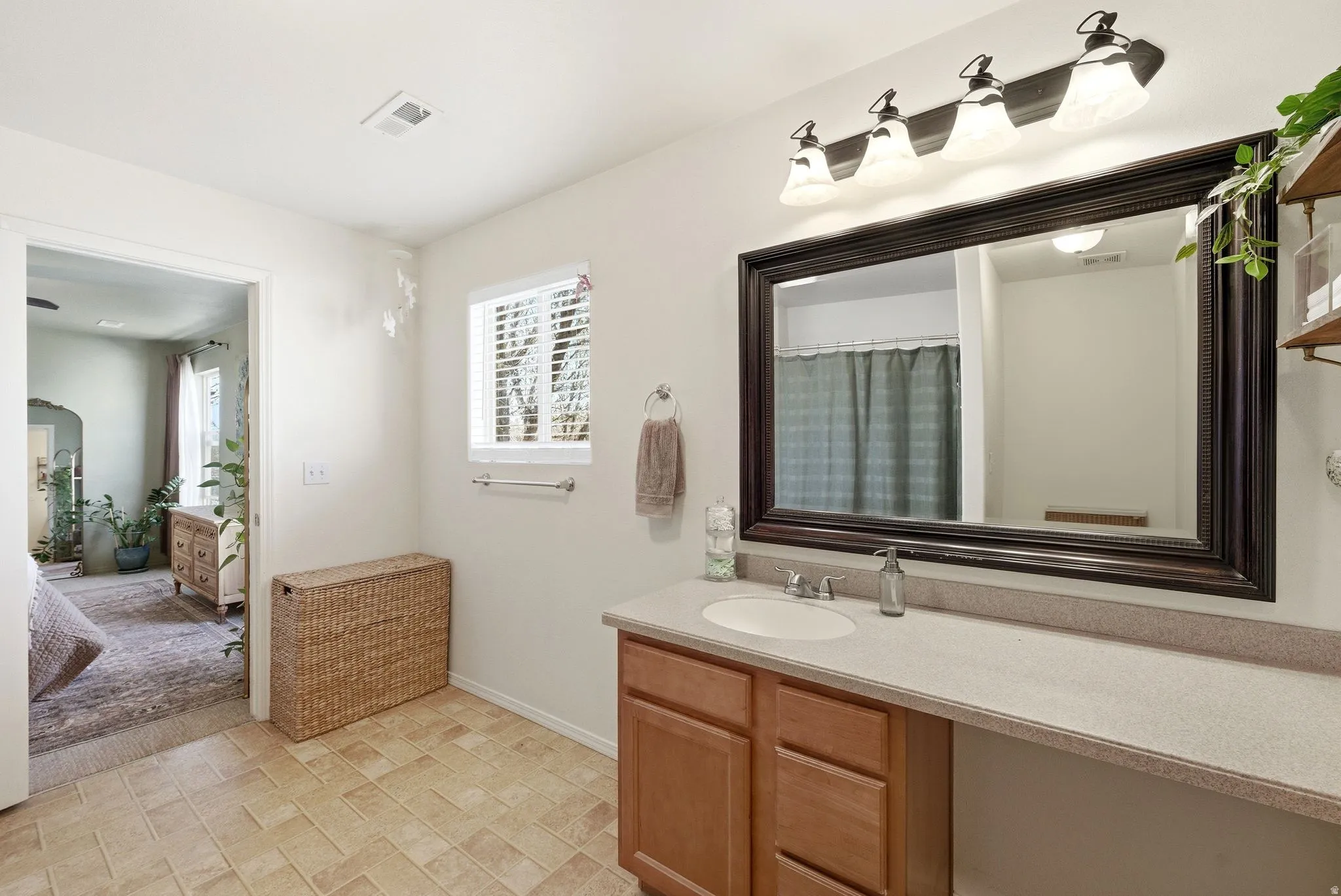 Ensuite bathroom with vanity, healthy amount of natural light, and curtained shower