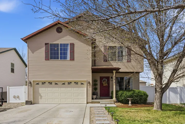 Traditional home featuring driveway, an attached garage, and a porch