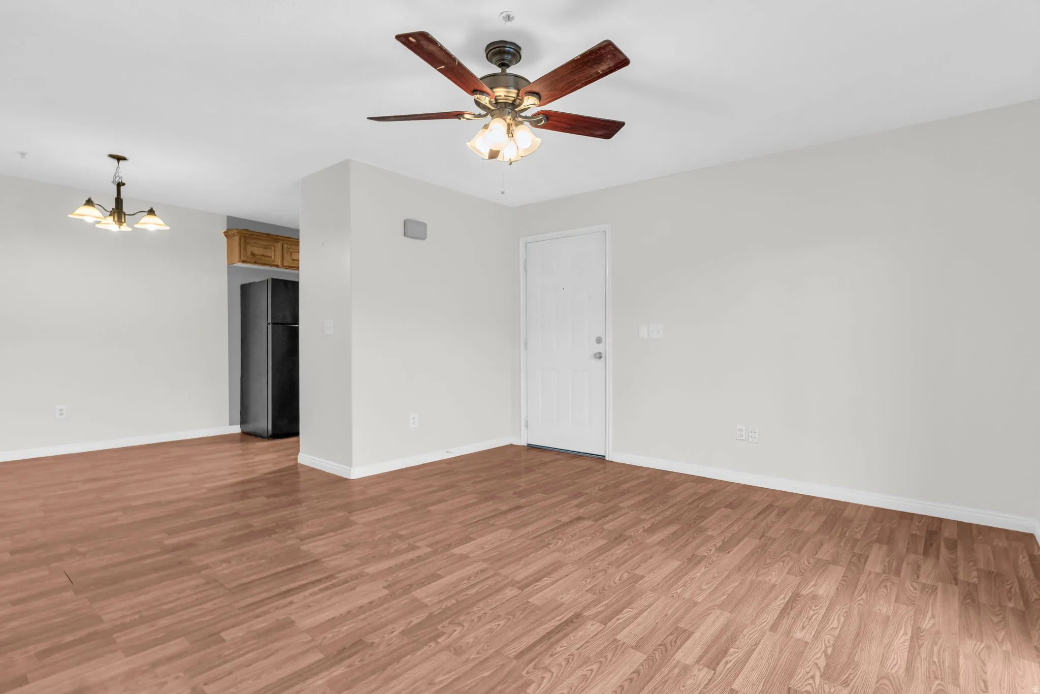 Unfurnished room with suspended lighting, light wood-style flooring, and ceiling fan
