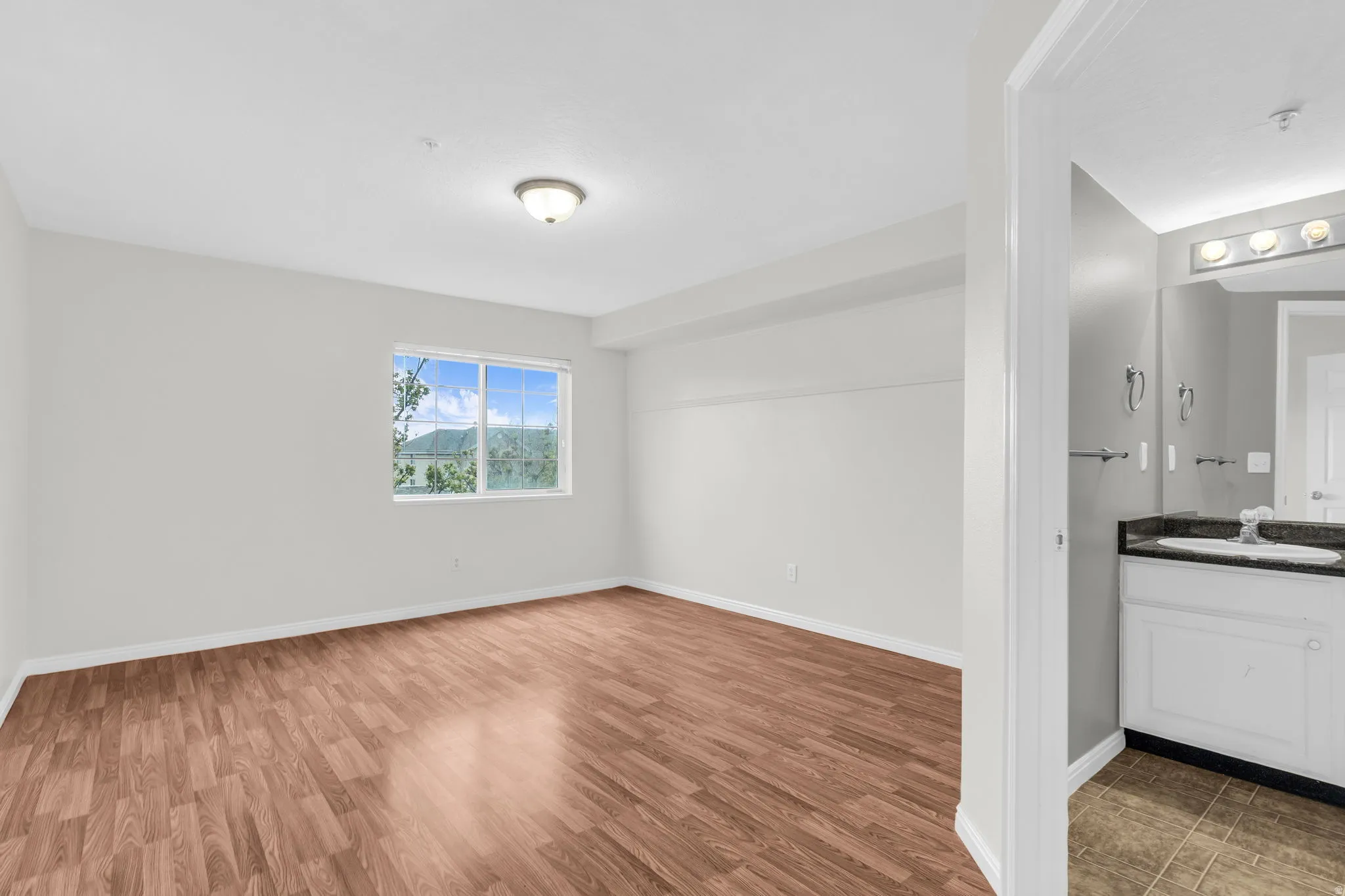 Empty room with light wood-style flooring and baseboards