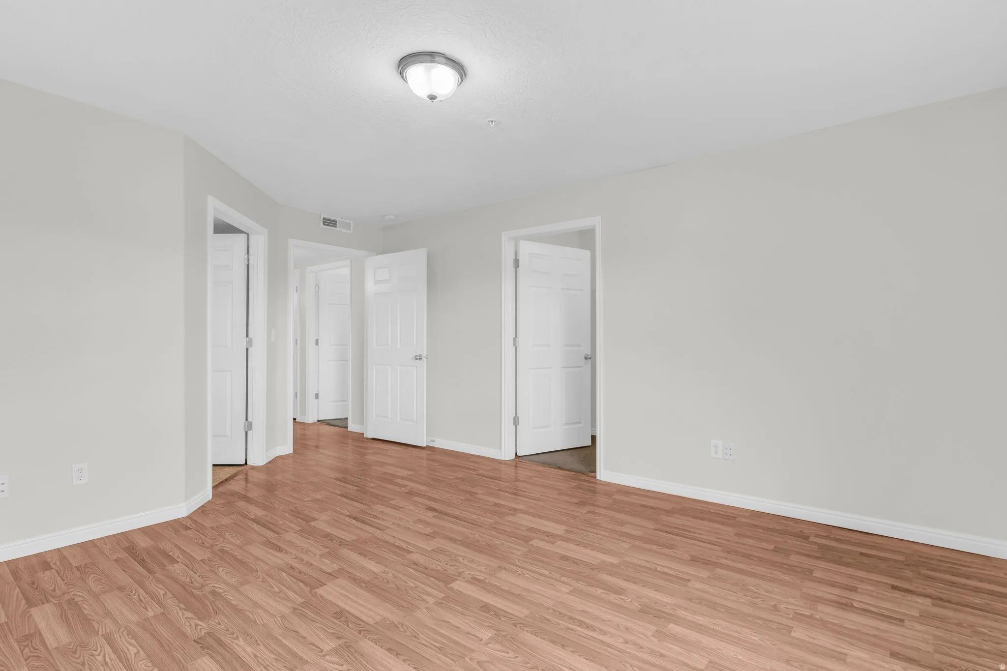 Unfurnished bedroom with light wood-type flooring and baseboards