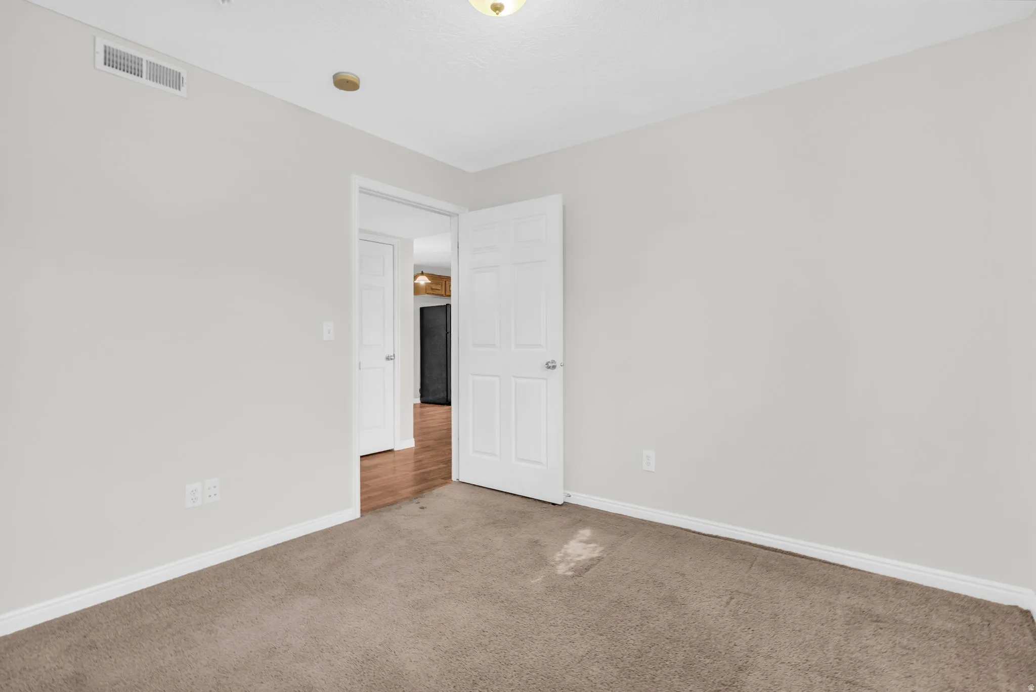 Carpeted spare room featuring baseboards