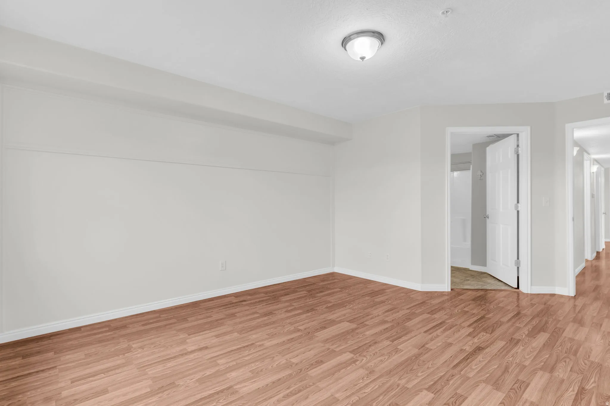 Empty room with light wood-type flooring and baseboards