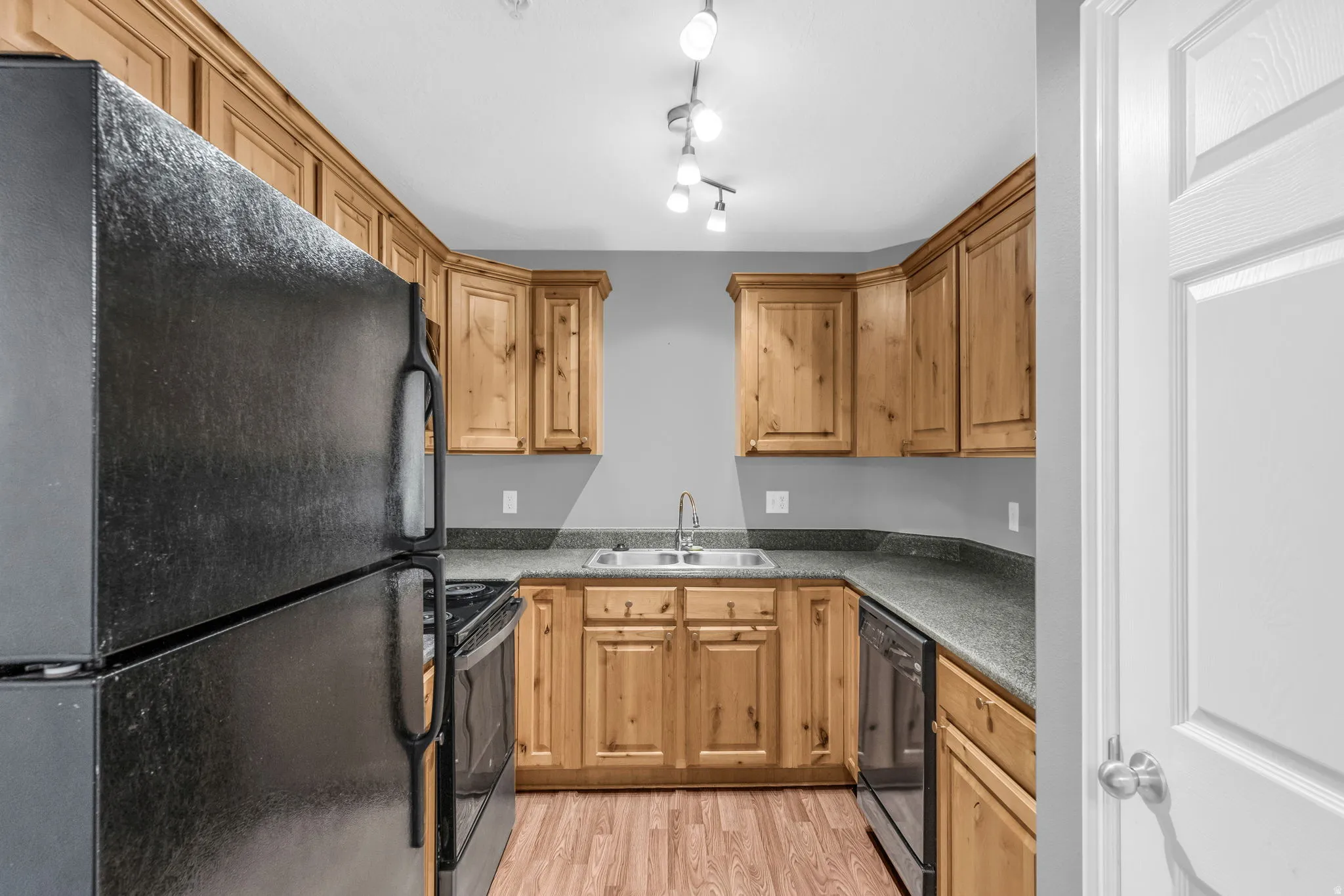 Kitchen with black appliances and light wood-style floors
