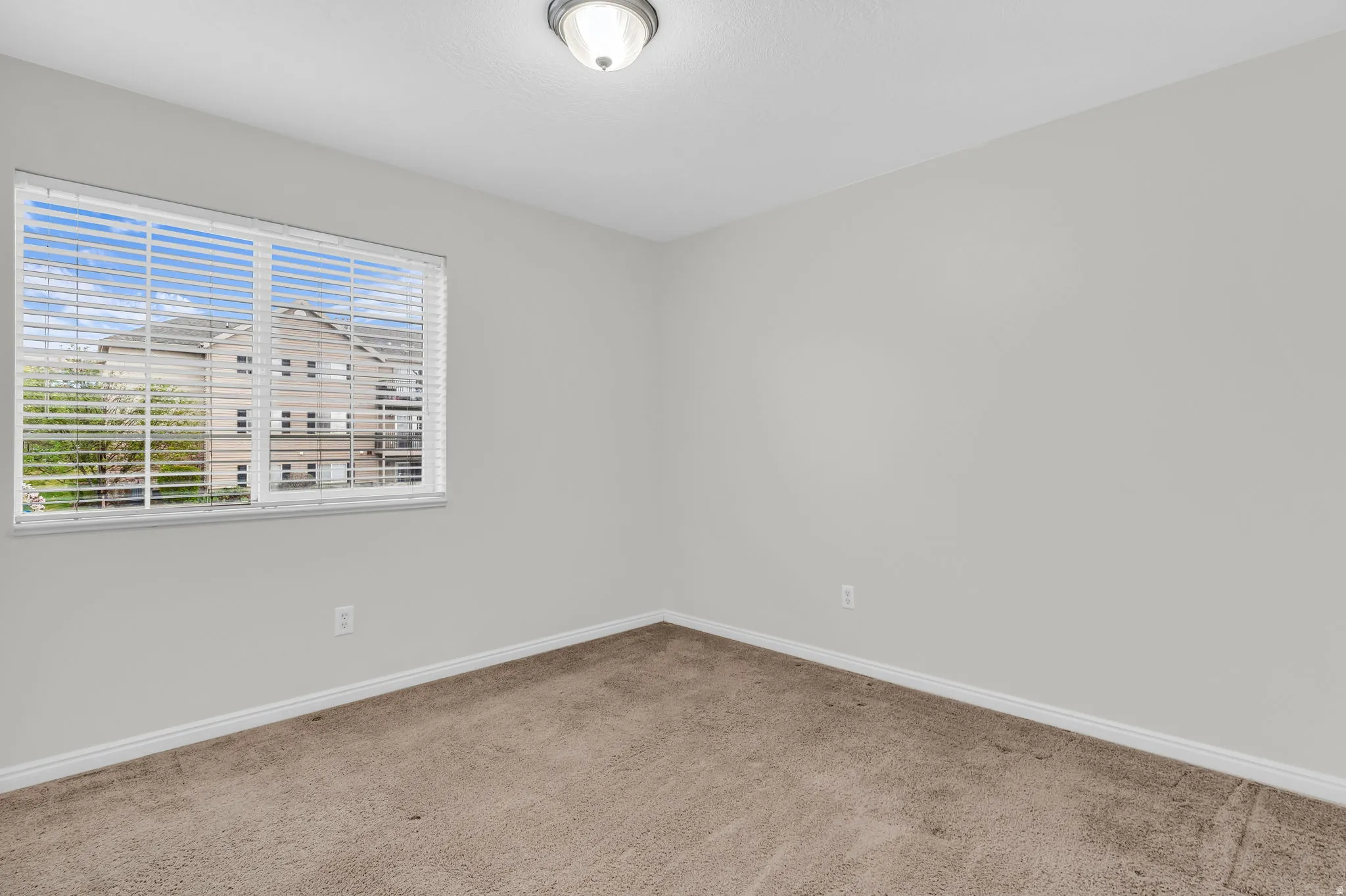 Carpeted empty room featuring baseboards