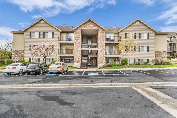View of apartment building / complex with uncovered parking