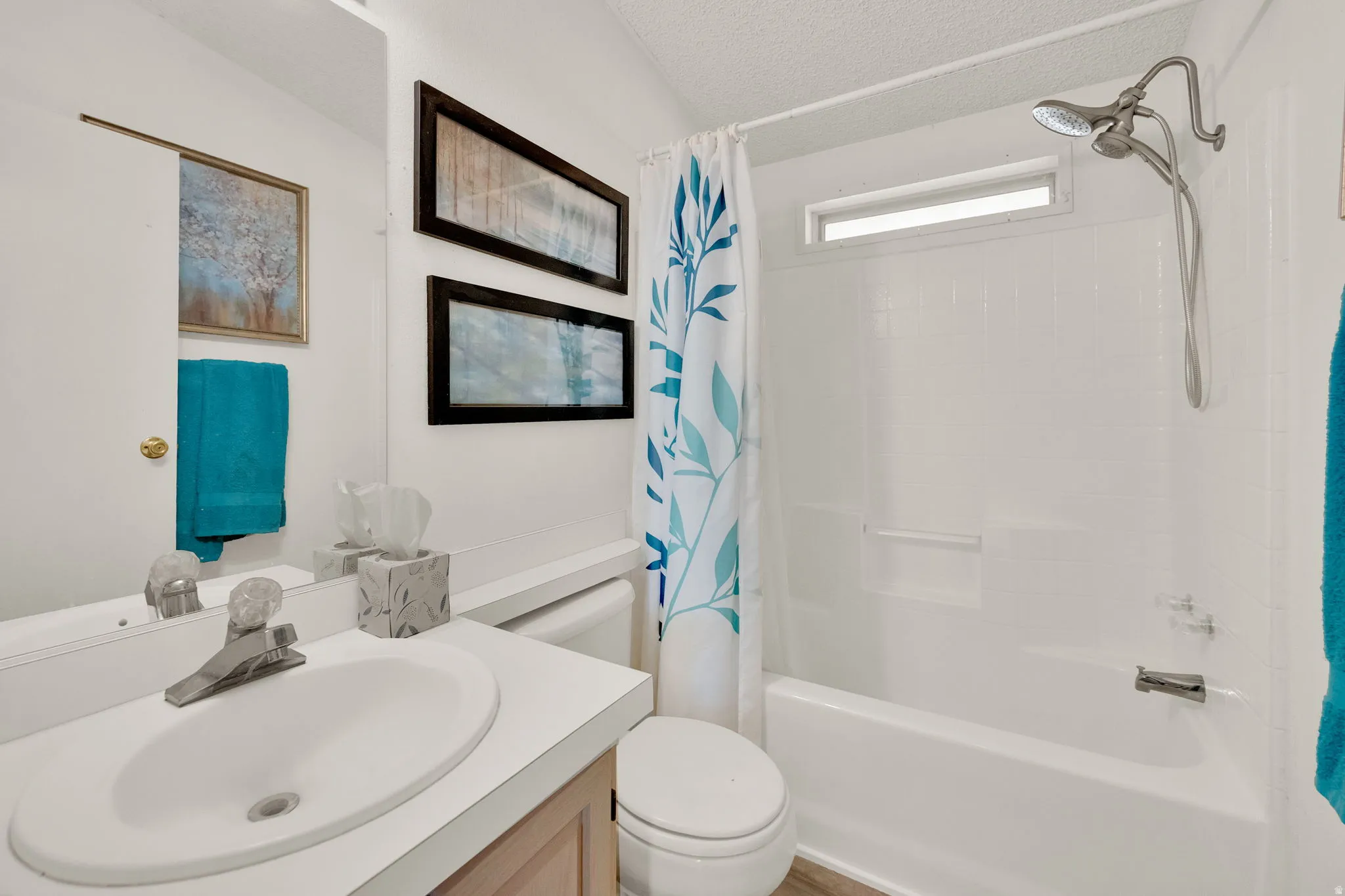 Guest Bathroom with vanity, shower / bath combination with curtain, and a textured ceiling