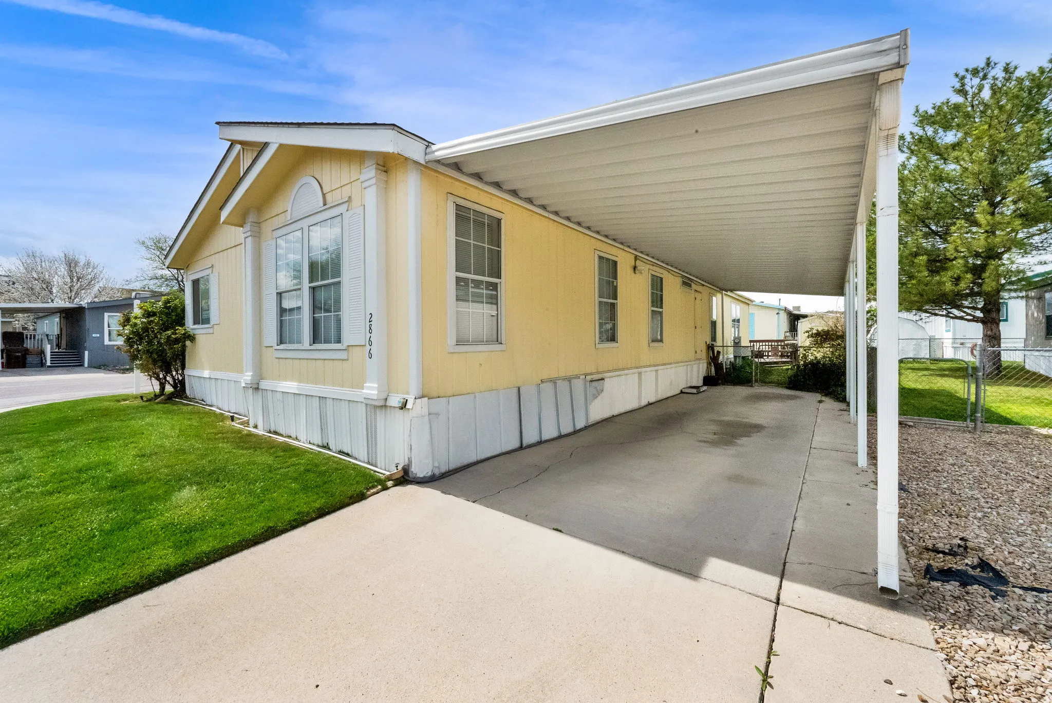 View of home's exterior featuring an attached carport, a patio, and driveway