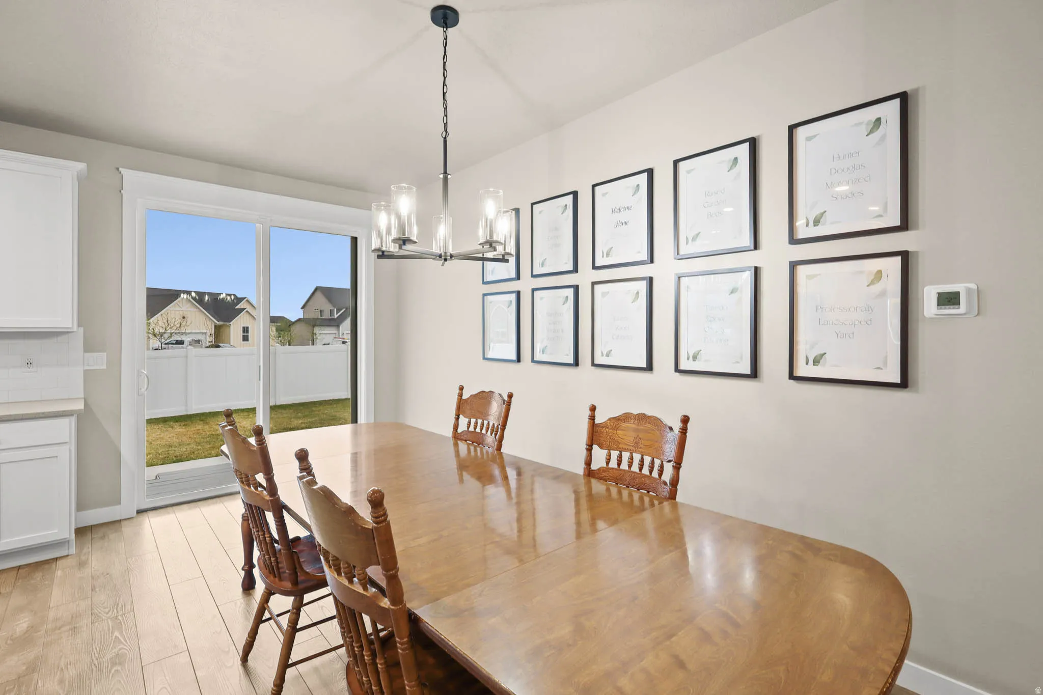 Dining area with light LVP flooring and a chandelier