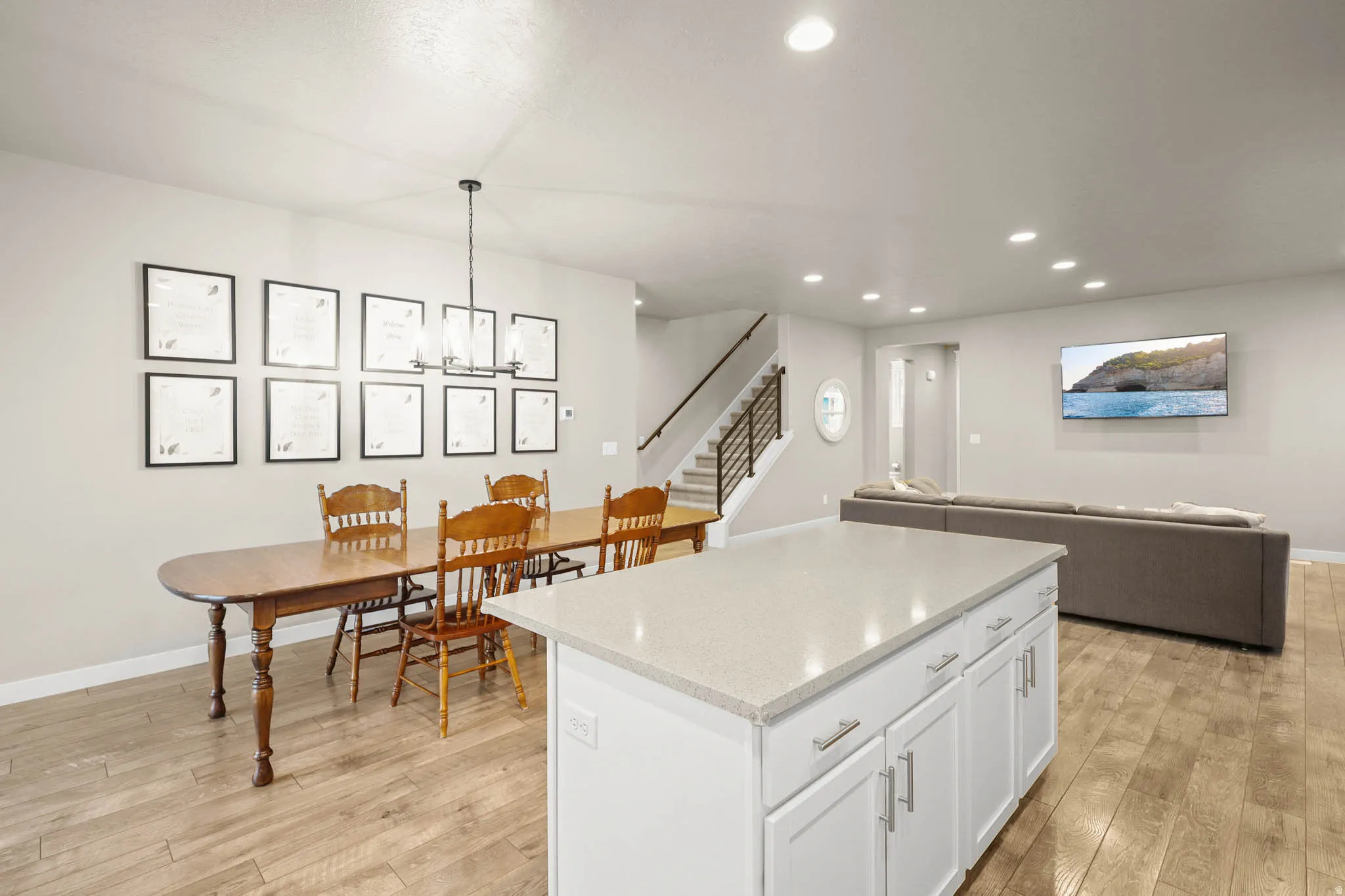 Kitchen with white cabinets, open floor plan, a center island, and light wood-style floors