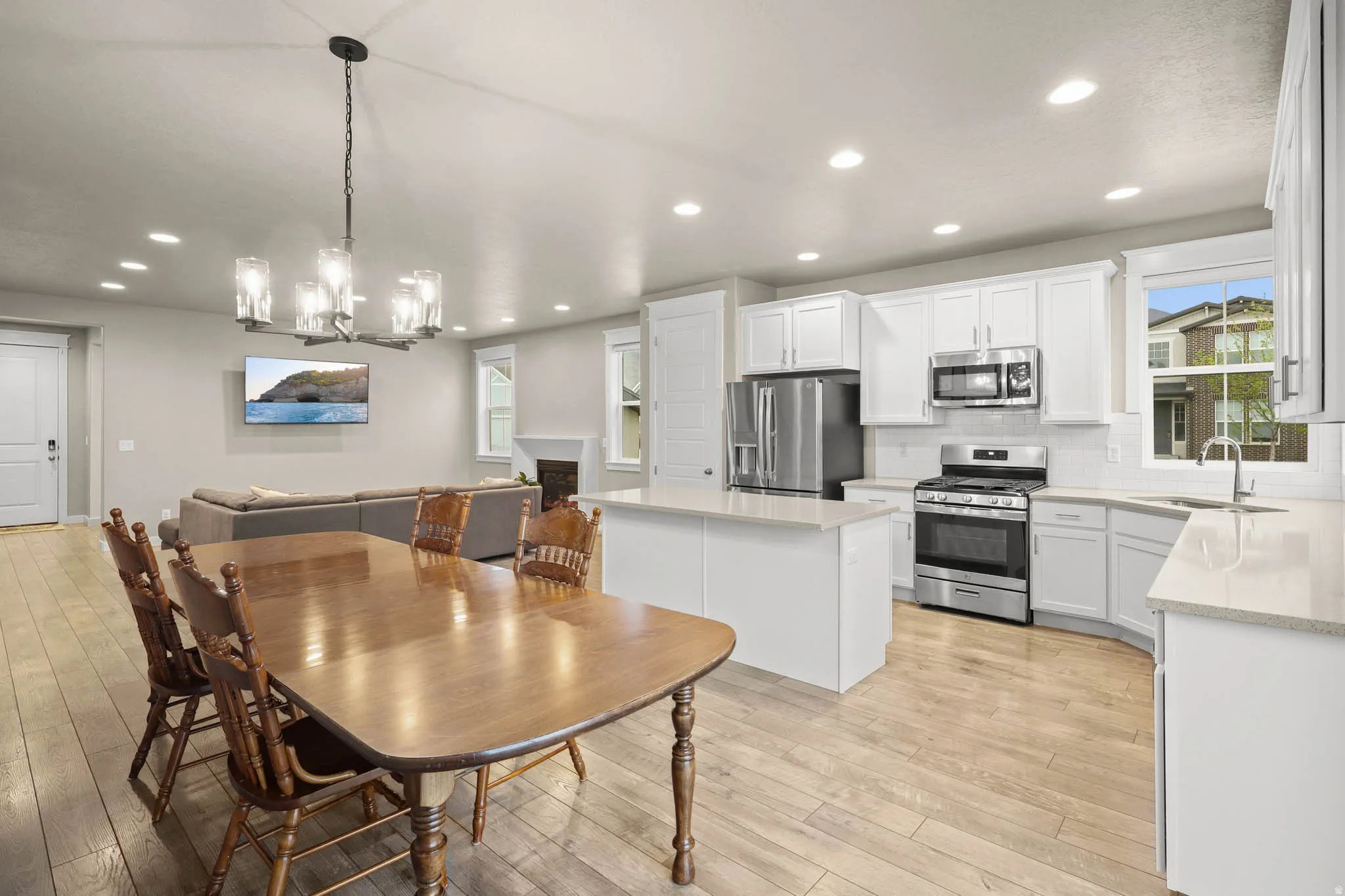 Dining area featuring a fireplace, suspended lighting, and light LVP floors