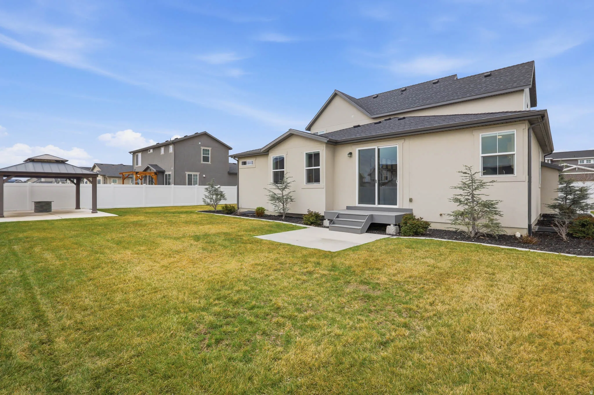 Back of house with a patio, a gazebo, stucco siding, and roof with shingles