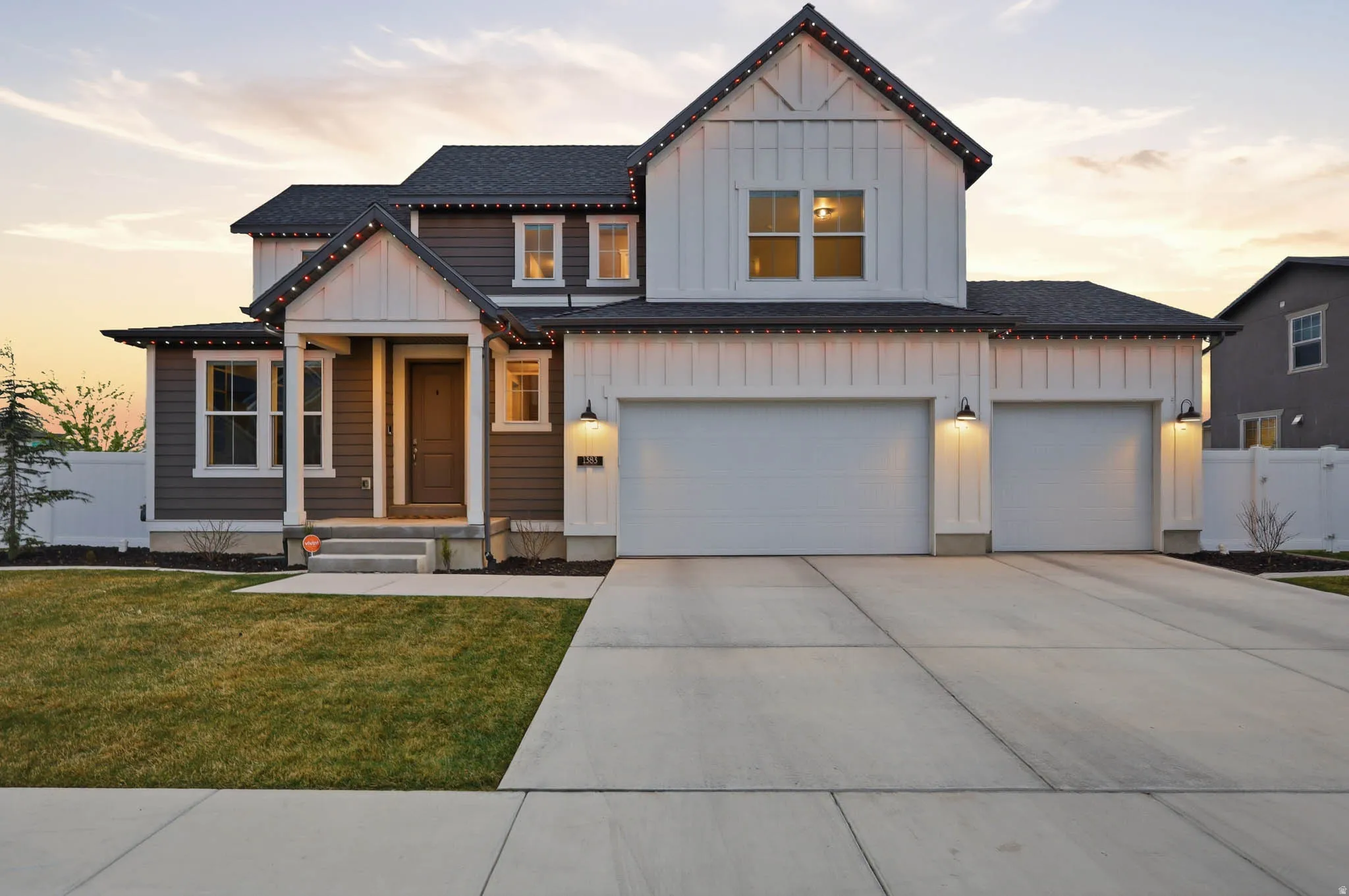 Modern farmhouse style home featuring board and batten siding, a shingled roof, concrete driveway, and a garage
