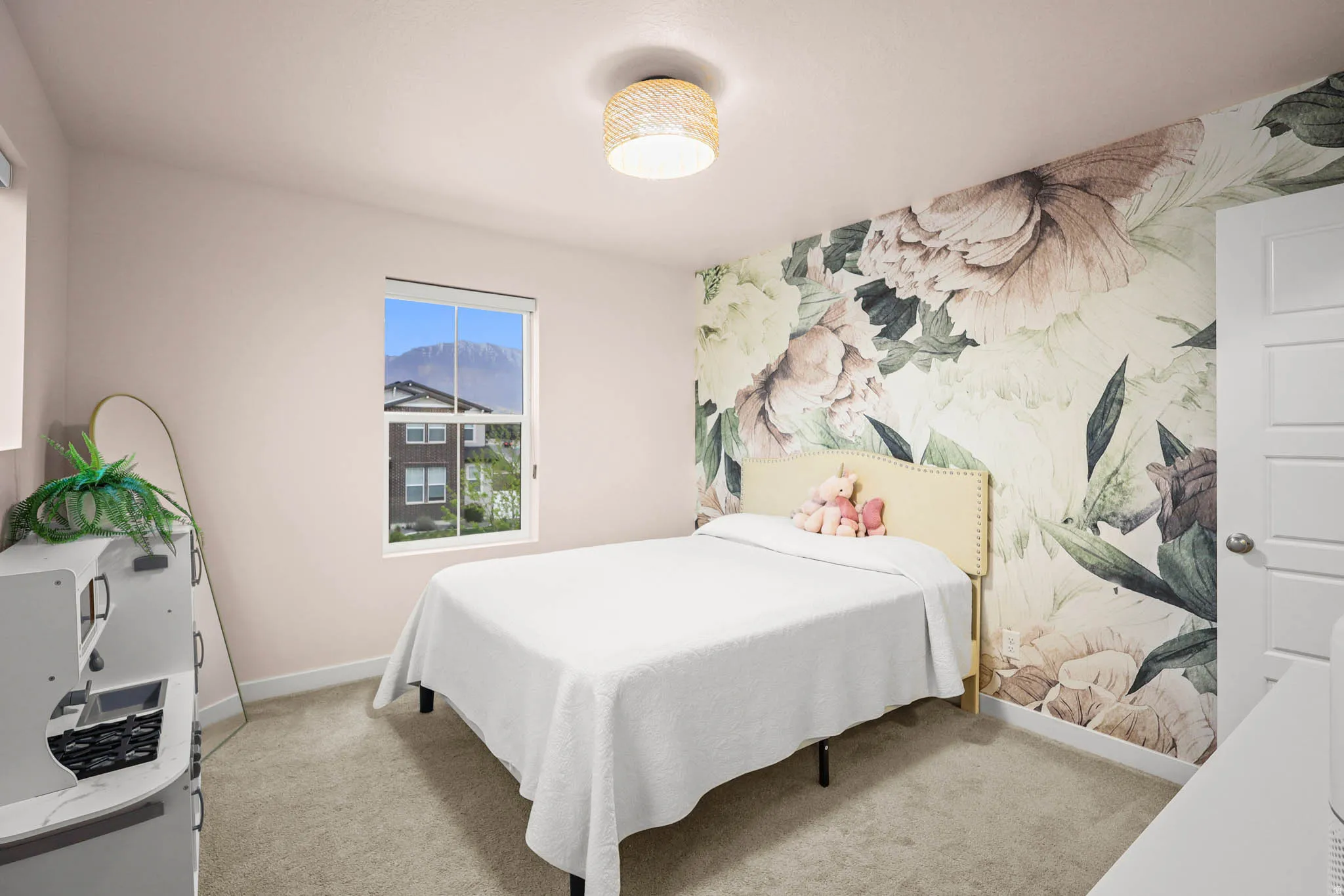 Bedroom with light carpet, an accent wall, and wallpapered walls