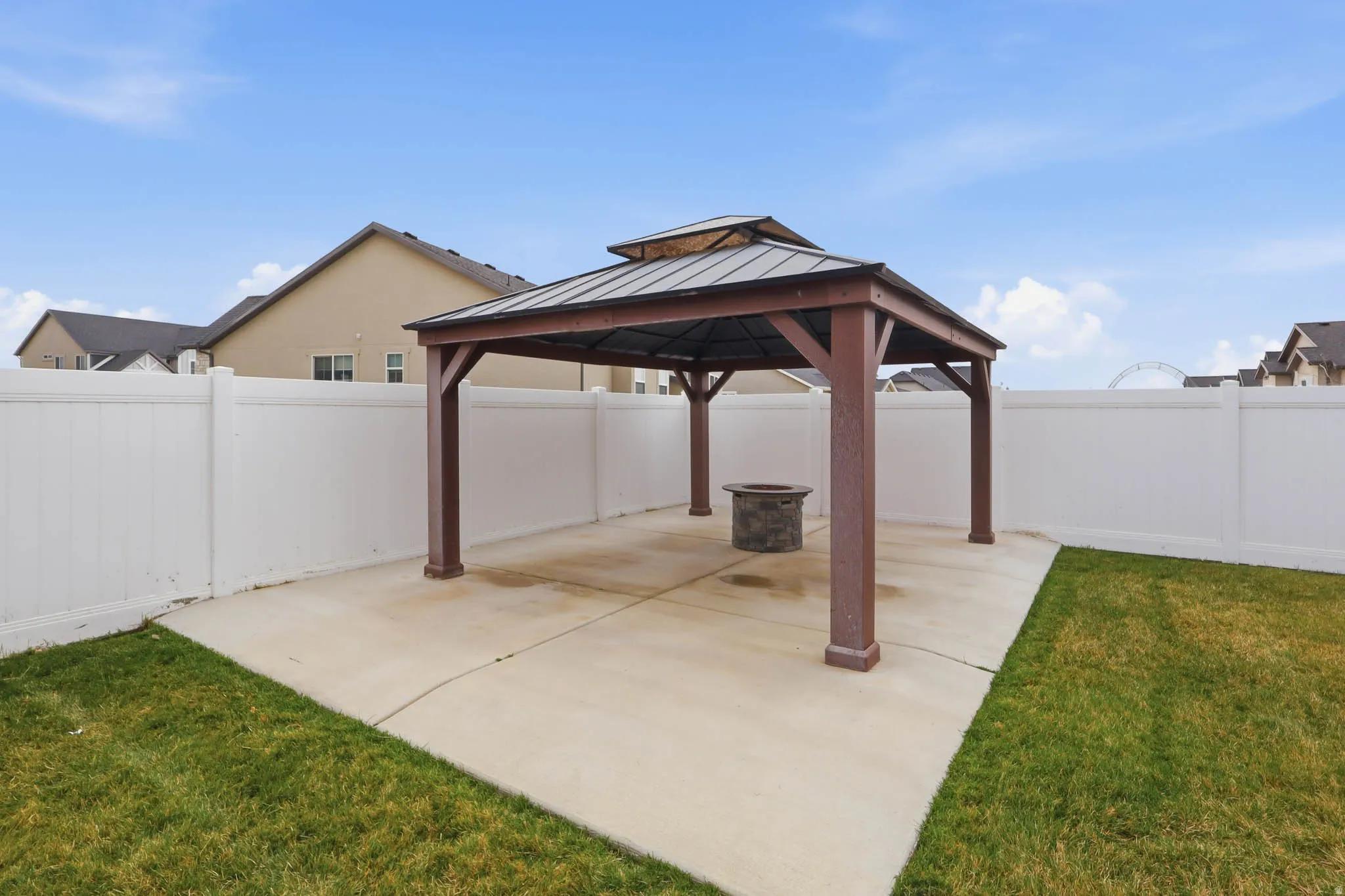 Fenced backyard featuring a patio area and a gazebo