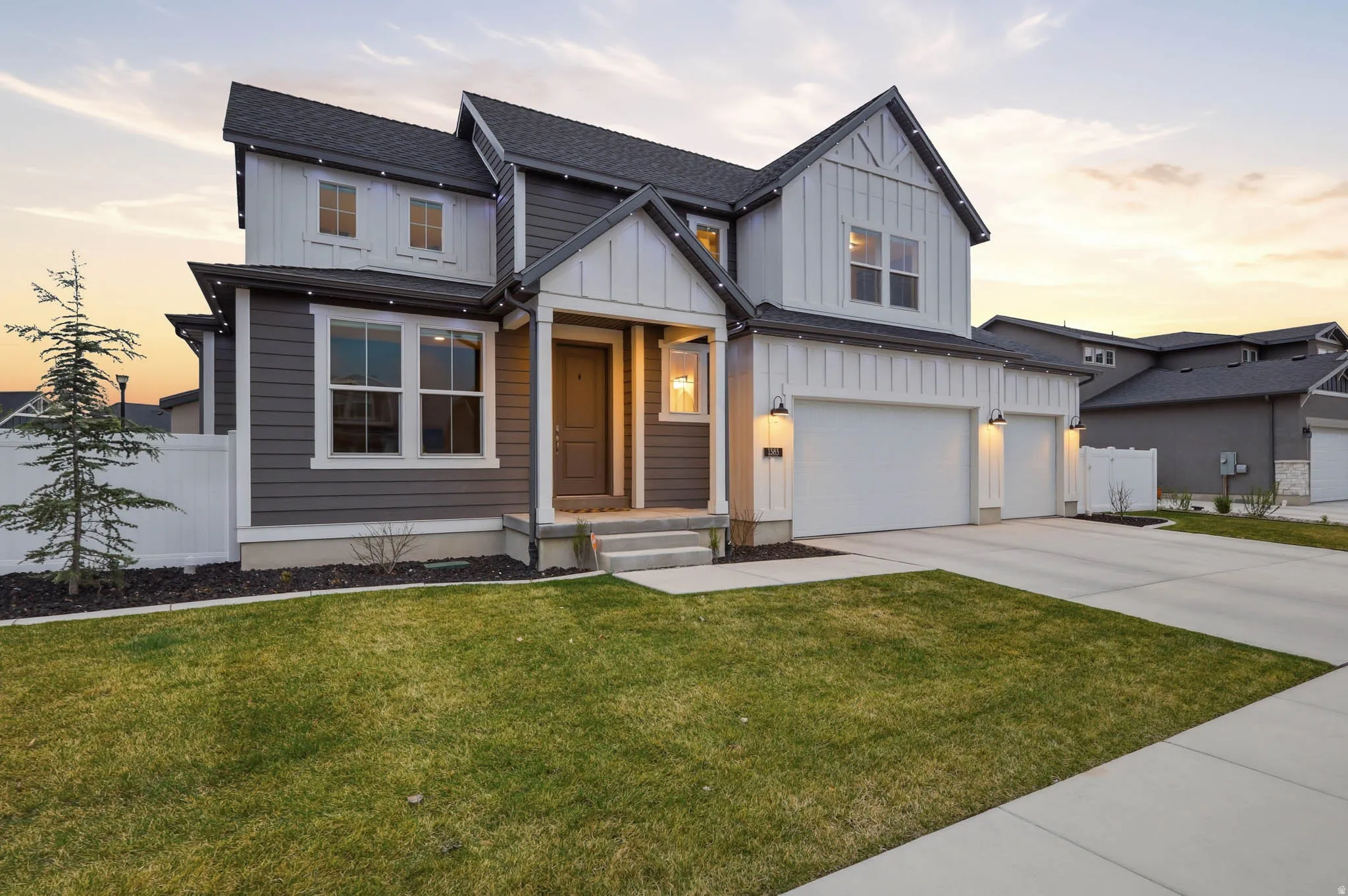 Modern inspired farmhouse featuring board and batten siding, concrete driveway, a garage, and roof with shingles