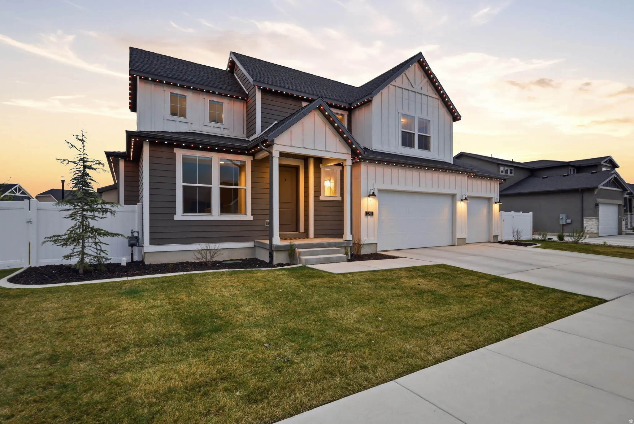 Modern inspired farmhouse with board and batten siding, concrete driveway, a garage, roof with shingles, and a gate
