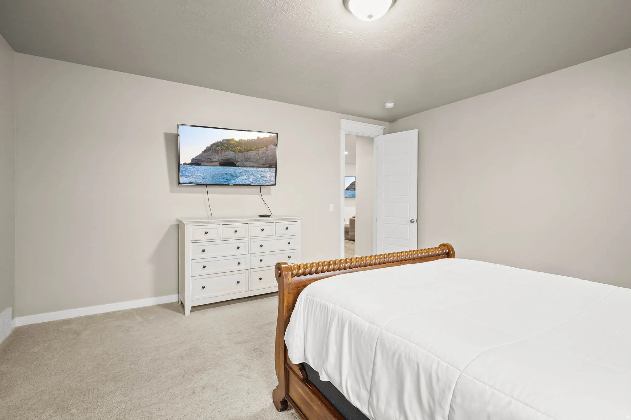 Primary Bedroom featuring light carpet and baseboards
